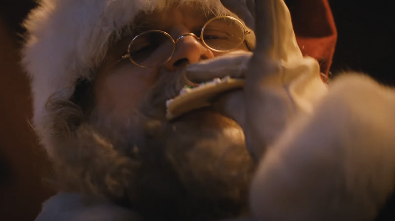 Violent Night santa eating a cookie