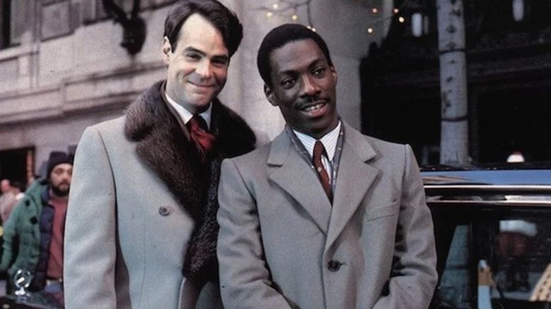 Dan Aykroyd and Eddie Murphy standing in grey coats in Trading Places